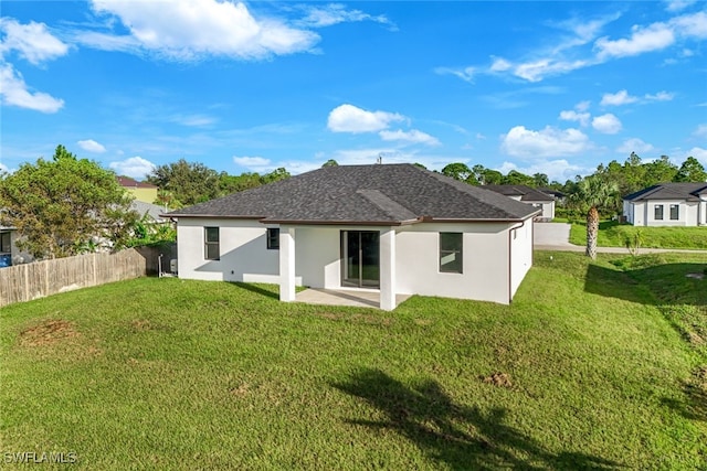 rear view of property with a yard and a patio area