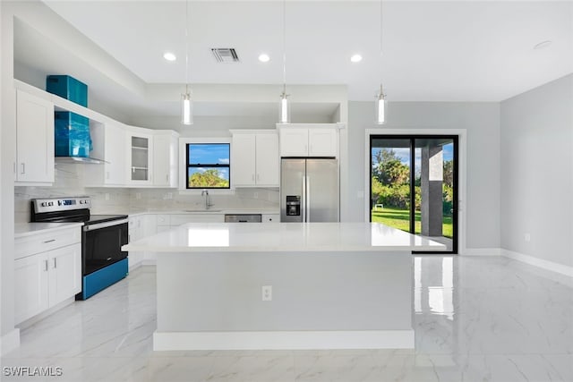 kitchen featuring white cabinetry, appliances with stainless steel finishes, a center island, and decorative light fixtures