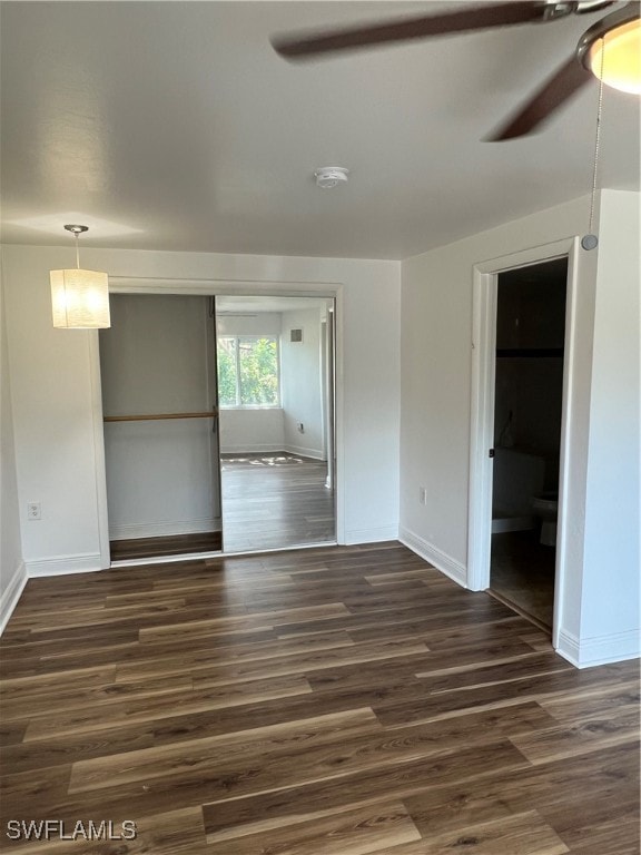 unfurnished room with dark hardwood / wood-style flooring and ceiling fan