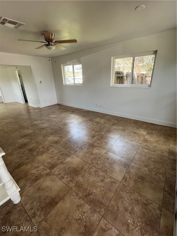 unfurnished room featuring a healthy amount of sunlight and ceiling fan