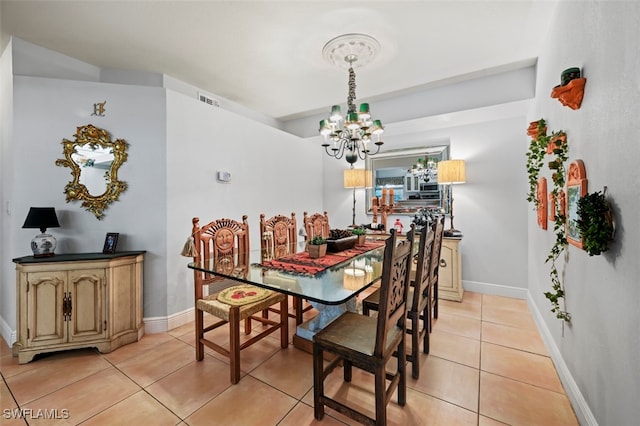 tiled dining room with a chandelier