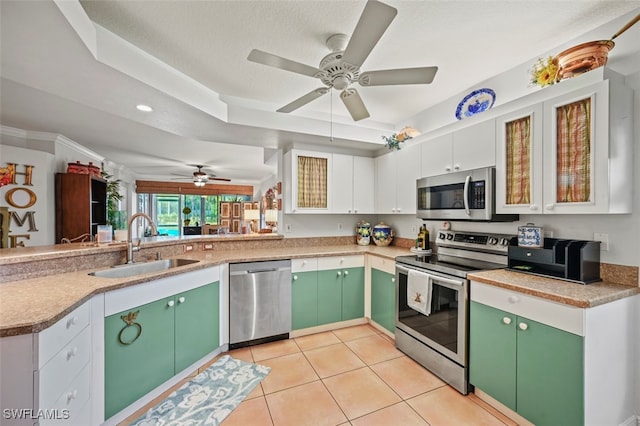 kitchen featuring green cabinets, sink, white cabinets, light tile patterned floors, and appliances with stainless steel finishes