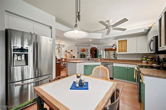 kitchen featuring a kitchen island, hanging light fixtures, white cabinetry, light tile patterned floors, and appliances with stainless steel finishes