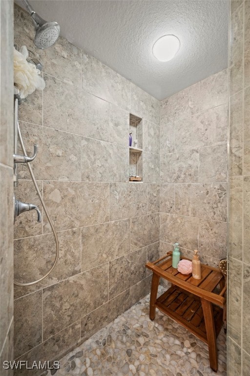 bathroom featuring a tile shower and a textured ceiling