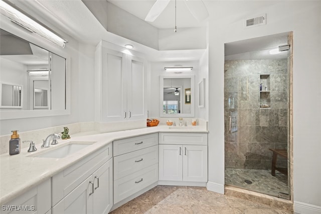 bathroom with vanity, a tile shower, and ceiling fan