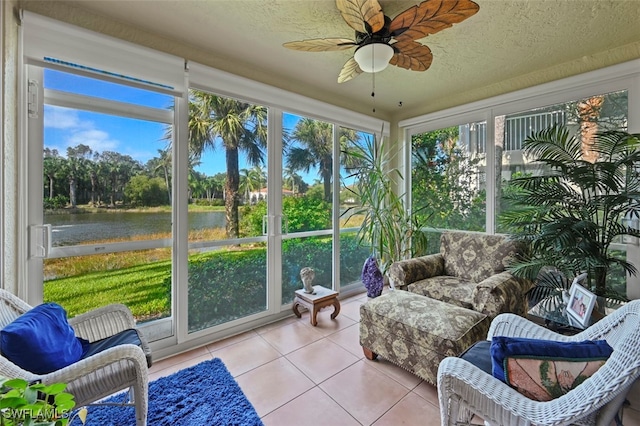 sunroom featuring a water view and ceiling fan