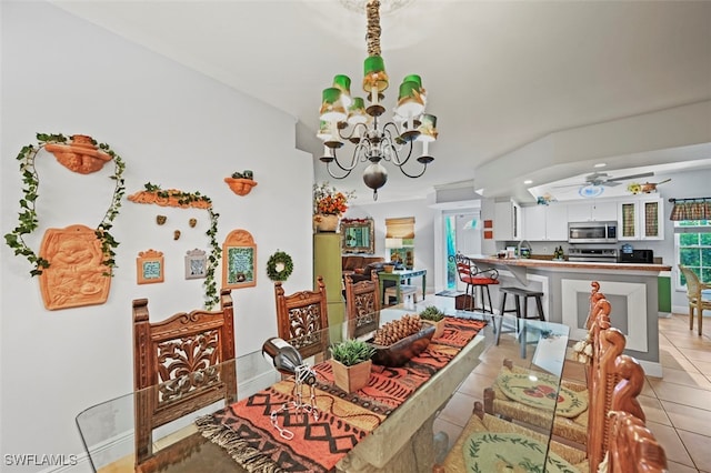 dining area featuring light tile patterned flooring and ceiling fan with notable chandelier