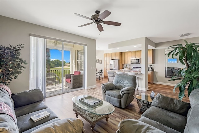 living room featuring light wood-type flooring and ceiling fan