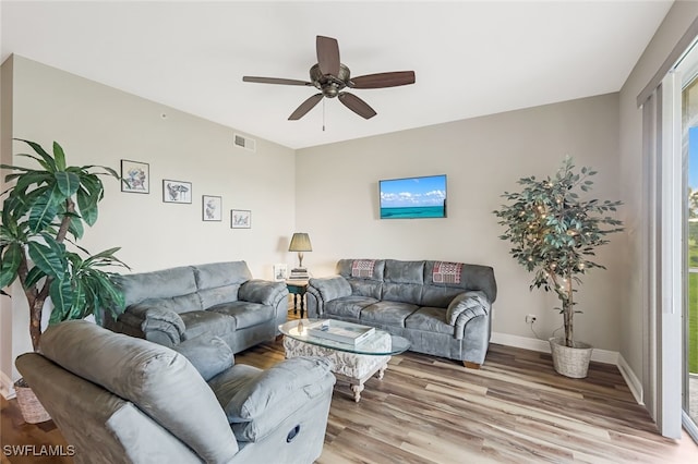 living room featuring wood-type flooring and ceiling fan