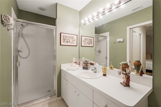 bathroom featuring vanity, a shower with shower door, and tile patterned floors