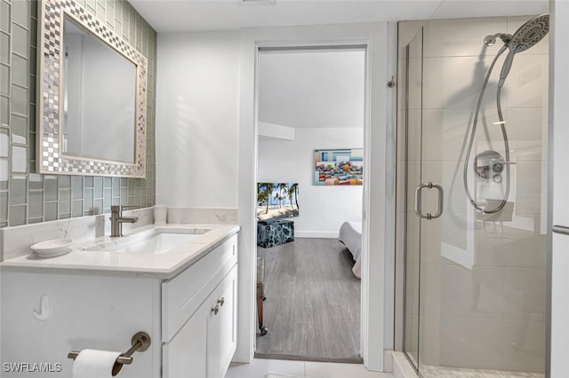 bathroom with hardwood / wood-style flooring, vanity, and walk in shower