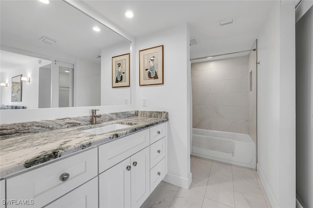 bathroom featuring vanity and tiled shower / bath