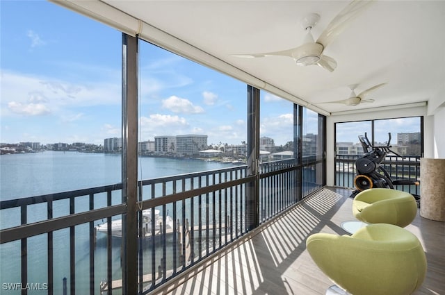 sunroom / solarium featuring a water view and ceiling fan