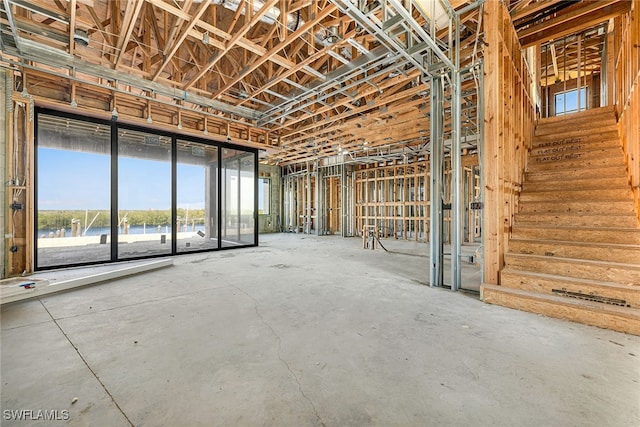 misc room with a water view and concrete floors