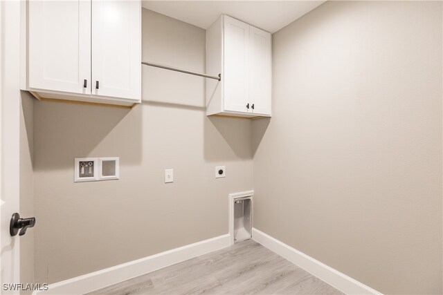 clothes washing area featuring cabinet space, light wood finished floors, baseboards, hookup for a washing machine, and electric dryer hookup