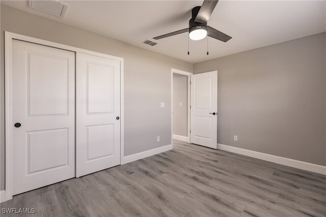 unfurnished bedroom with a closet, visible vents, baseboards, and light wood finished floors