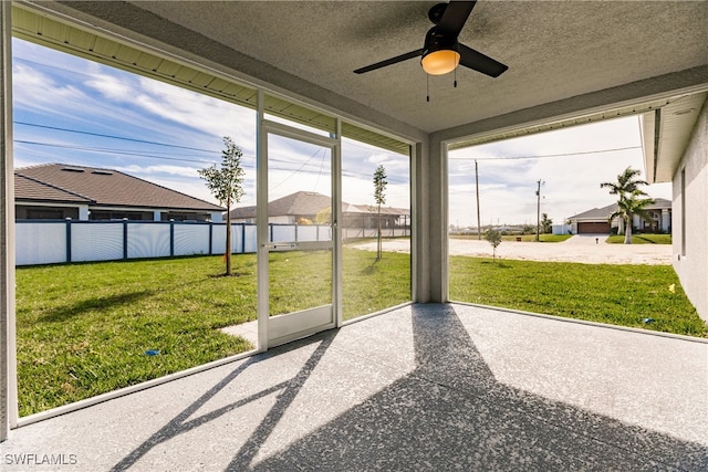 unfurnished sunroom featuring a ceiling fan