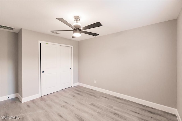 unfurnished bedroom with light wood-style flooring, a closet, visible vents, and baseboards