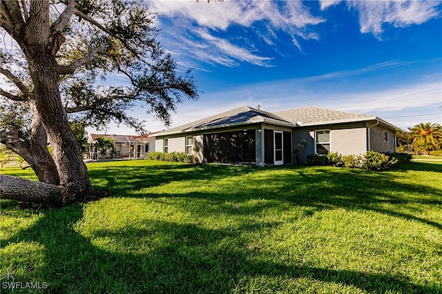 back of house featuring a lawn and stucco siding