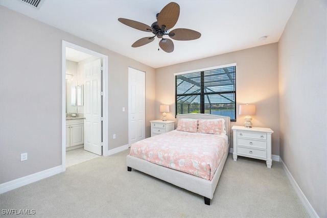 carpeted bedroom with ensuite bathroom and ceiling fan