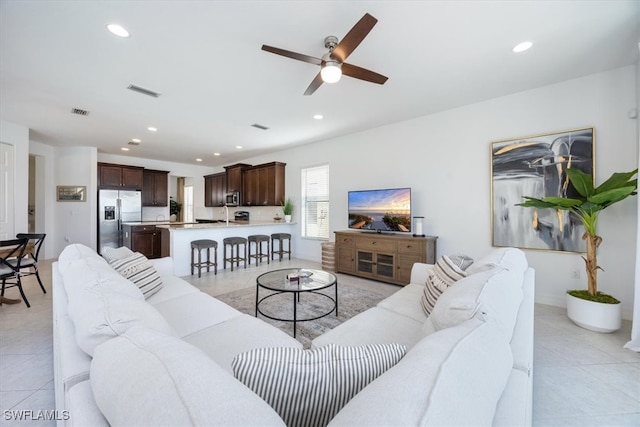 living room featuring light tile patterned floors and ceiling fan