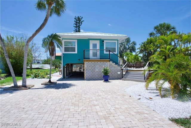 raised beach house featuring a carport