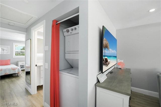 washroom featuring stacked washer and dryer and light hardwood / wood-style floors