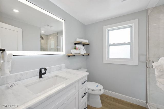 bathroom with vanity, hardwood / wood-style flooring, toilet, and walk in shower