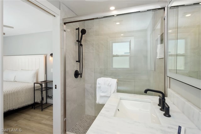 bathroom featuring hardwood / wood-style flooring, vanity, and a shower with door