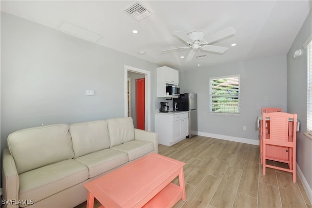 living room featuring light hardwood / wood-style floors and ceiling fan