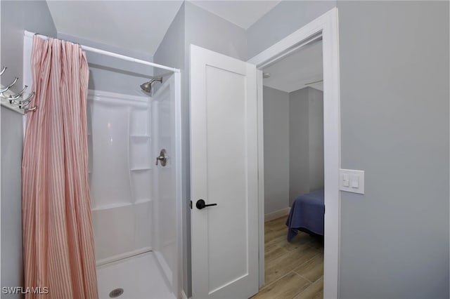 bathroom with a shower with shower curtain and hardwood / wood-style flooring