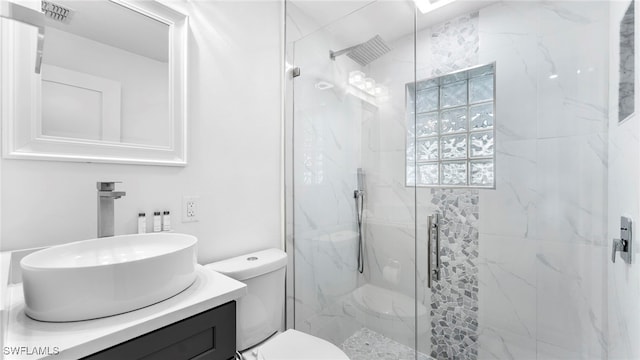 bathroom featuring toilet, a shower with door, and vanity