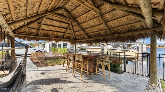 view of patio / terrace with a gazebo, exterior bar, and a water view