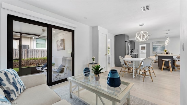 living room featuring a chandelier and light hardwood / wood-style flooring