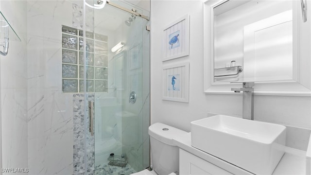 bathroom with a shower with shower door, sink, and toilet