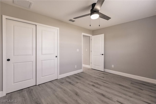 unfurnished bedroom featuring ceiling fan, light hardwood / wood-style flooring, and a closet