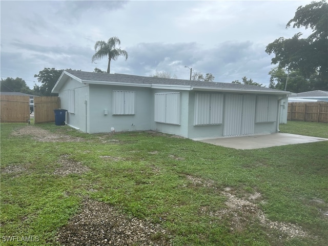 back of property featuring a patio area and a lawn