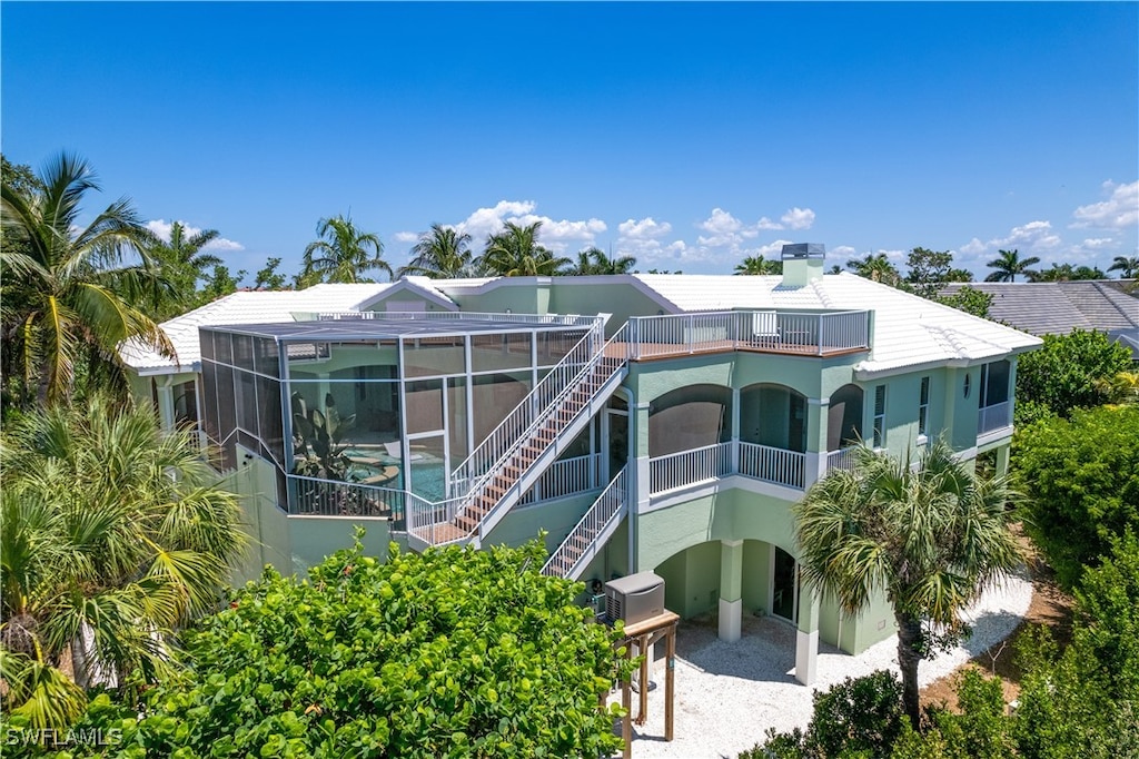 back of property with a lanai and a balcony