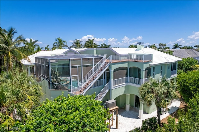 back of property with a lanai and a balcony