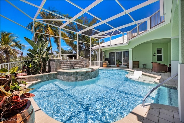 view of pool with glass enclosure, a patio area, ceiling fan, and an in ground hot tub