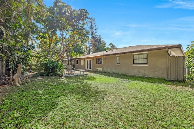 rear view of property with a yard