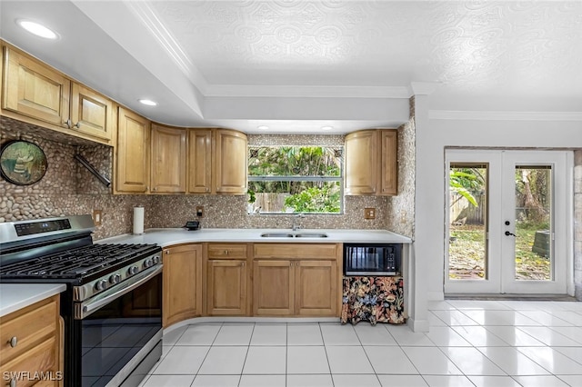 kitchen featuring stainless steel range with gas stovetop, crown molding, a healthy amount of sunlight, and sink