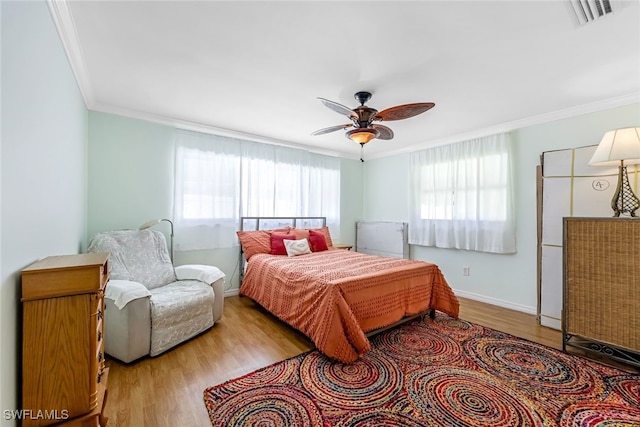 bedroom featuring ornamental molding, light hardwood / wood-style floors, and ceiling fan