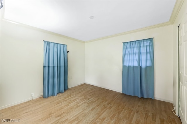 empty room with crown molding and wood-type flooring