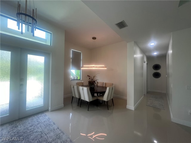 dining space with a wealth of natural light, a chandelier, and french doors