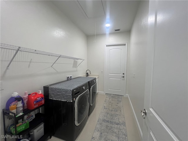 laundry room featuring sink, light tile patterned flooring, and washing machine and dryer