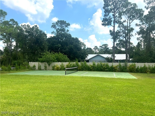 view of home's community featuring a lawn and tennis court