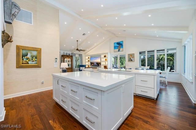 kitchen featuring dark hardwood / wood-style flooring, a center island, white cabinetry, and ceiling fan