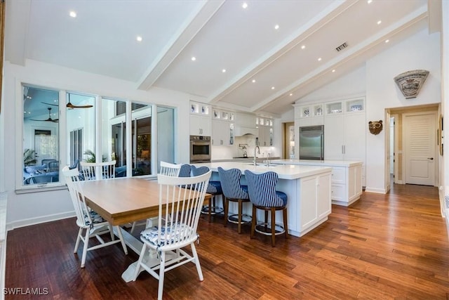 dining area with dark wood-type flooring, high vaulted ceiling, sink, ceiling fan, and beamed ceiling