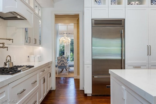 kitchen with white cabinets, stainless steel appliances, and dark hardwood / wood-style floors